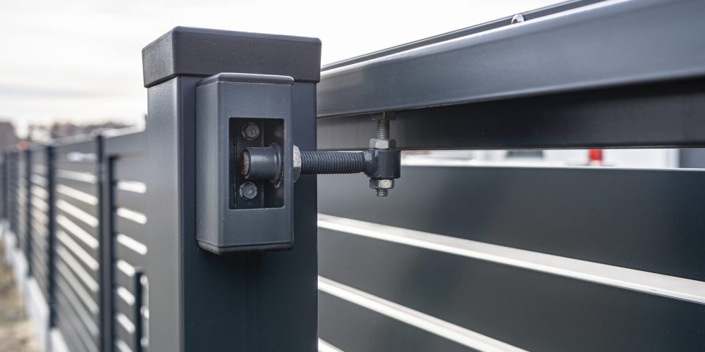 Modern sliding entrance gate in anthracite color, visible upper guide rollers.