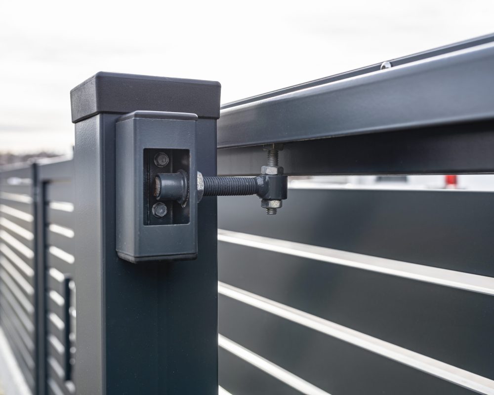 Modern sliding entrance gate in anthracite color, visible upper guide rollers.